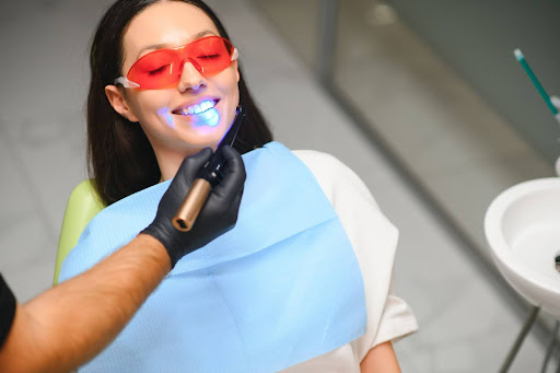 Female patient having a dental filling cured with blue light in a dentist