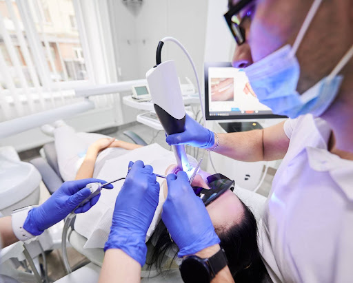 Dentists using modern high-precision dental technology for safe teeth whitening treatments